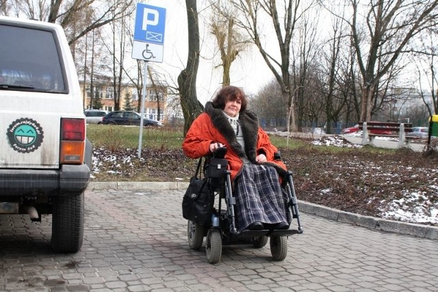 Anna Sowa pokazuje, że koperta dla osób niepełnosprawnych na parkingu przy ulicy Szymanowskiego w Kielcach przed dawną siedzibą ratusza jest za wąska. Wózek i auto nie zmieszczą się obok siebie.