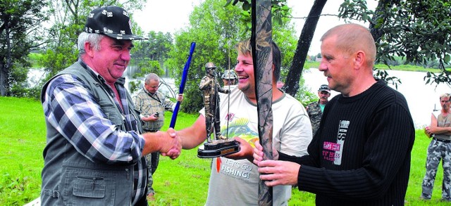 Stefan Kwiatkowski (z lewej) odbiera nagrodę od organizatorów:  Tomasza Wesołowskiego i Andrzeja Sokołowskiego