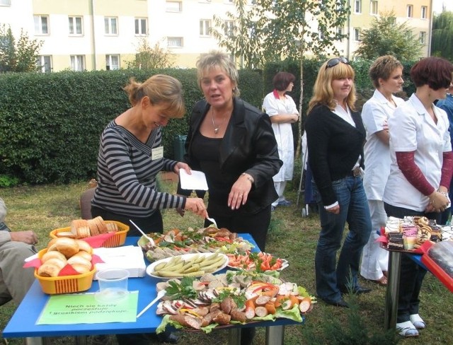 Podczas pikniku nie mogło zabraknąć tradycyjnych polskich potraw - ogórka kiszonego, czy swojskiej kiełbasy. Na zdjęciu pracownice placówki zachęcają do poczęstunku. 