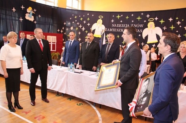 Władze samorządowe gminy Kluczewsko przekazują dyrektorowi dobromierskiej szkoły i nauczycielce akt nadania szkole imienia oraz portret majora Henryka Dobrzańskiego.