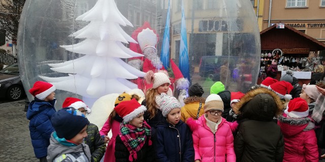 Spotkanie z Mikołajem jest atrakcją Jarmarku Świętego Mikołaja trwającego w czwartkowe południe na Rynku w Grudziądzu. Na scenie występują dzieci.