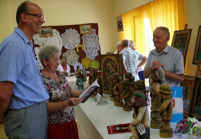 Wójt Radkowa Stanisław Herej zwiedza wystawę lokalnego rzeźbiarza Zdzisława Purchały z Kossowa.