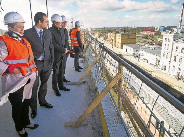 Wojewoda Ewa Mes (od lewej), Piotr Ciżkowicz, członek zarządu PKP i Tomasz Zaboklicki - prezes Pesy podziwiają z 3 piętra nowego dworca odremontowaną fasadę dworca wyspowego.