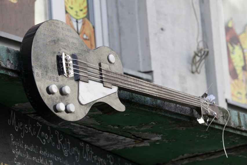Tablica w kształcie marmurowej gitary basowej na budynku...