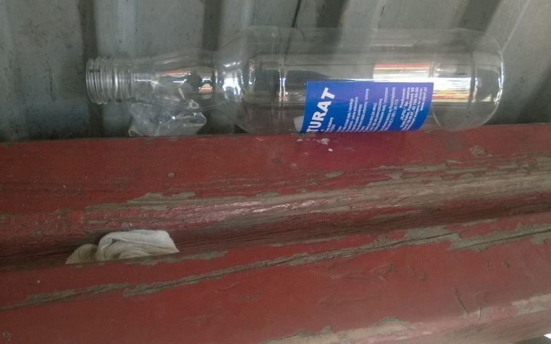 Puste butelki po wódce i denaturacie leżą na ławce w wiacie...