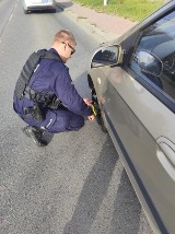 Świątniki Górne. Policjanci pomagali kierującej kobiecie wymienić koło w samochodzie 