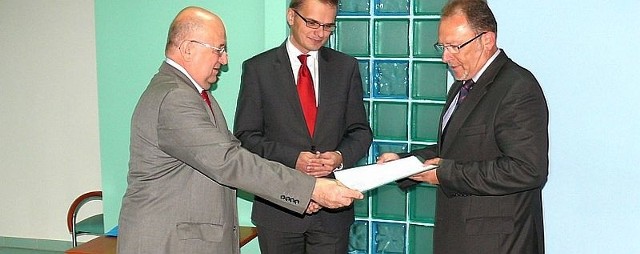 Dyrektor Marek Indyk i jego zastępca Robert Fila wręczają pozwolenie na działalność w specjalnej strefie dyrektorowi ekonomicznemu spółki Cell-Fast Andrzejowi Galakowi.