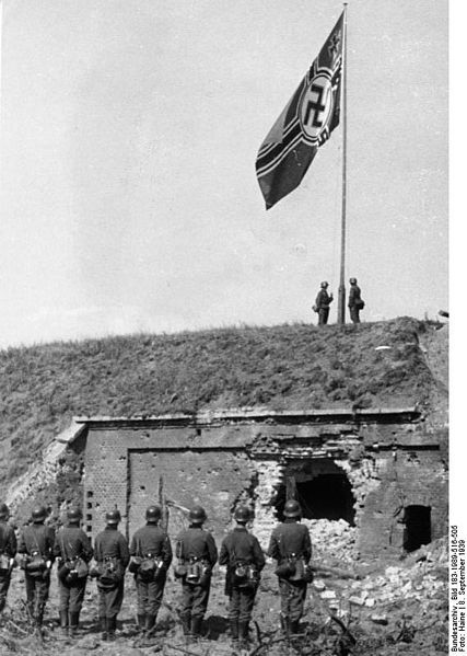 Niemcy wciagają hitlerowską flagę na ruinach polskich...