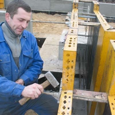 Marcin Czerniak z Lubeksu montuje szalunki do wylewania ław fundamentowych