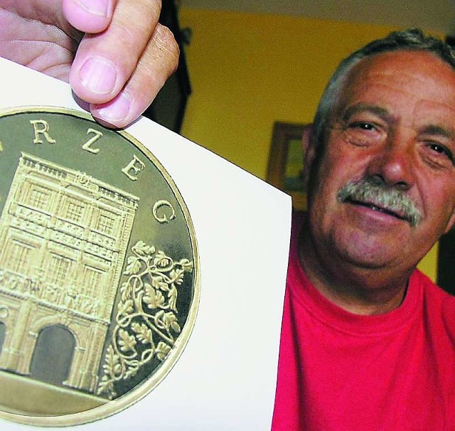Tadeusz Sadowiński, kolekcjoner, prezentuje wizerunek monety.