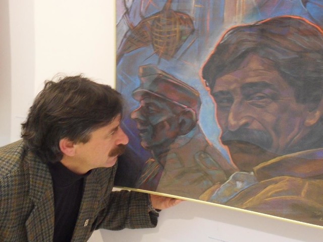 Jacek szpak przed swoim autoportretem w galerii w Krośnie.