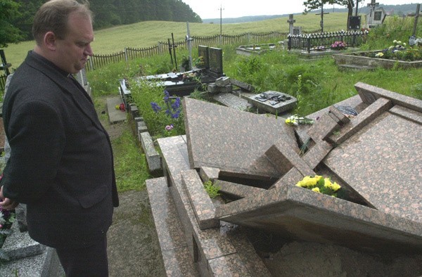 Ksiądz Mirosław Szepiotko, proboszcz parafii w Kopisku przy zniszczonych grobach