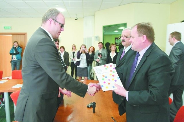 Wicemarszałek Baszko (z prawej) gratuluje burmistrzowi Szczuczyna otrzymania prawie 1 mln zł na targowisko