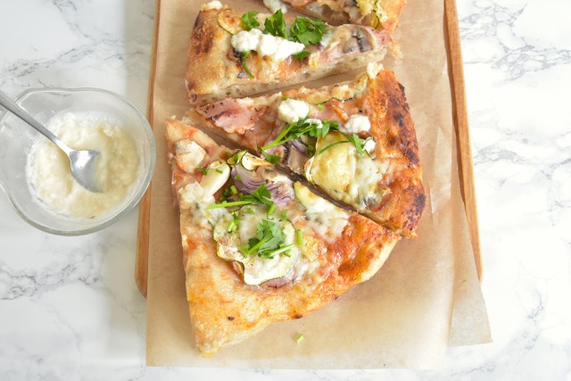 Domowa pizza z grzybami może być podawana z sosem chrzanowym i obsypana posiekaną świeżą natką pietruszki.