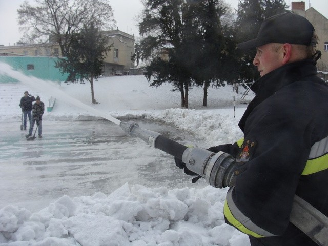 Strażak Jacek Łoś szykuje lodowisko przy Szkole Podstawowej nr 1