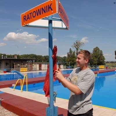 Jarosław Chlebek zdejmuje flagę oznaczającą zakaz kąpieli na basenie