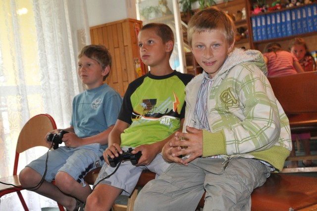 Marcel, Piotr i Kacper (od lewej) spędzają czas na ulubionych grach na playstation.