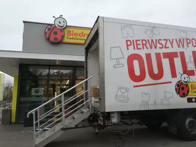 Biedronka Outlet Truck to pierwsza w Polsce mobilna towaroteka. W wielkiej ciężarówce znajdują się produkty w niższych cenach. Promocje sięgają nawet 70 procent!Wyprzedażowa przyczepa Biedronki pojawiła się pod sklepem tej sieci w Gorzowie przy ul. Olimpijskiej. Wielki truck zaparkował na parkingu przy Biedronce.Ten nietypowy sklep długi jest na kilkanaście metrów. Przy jego ścianach znajdują się palety i kartony z asortymentem sieci sklepu w bardzo atrakcyjnych cenach. Przy wejściu do przyczepy znajduje się jednoosobowa kasa.Przeczytaj też:  Niedziele handlowe w 2020 r. Co się zmienia? Kiedy sklepy będą zamknięte, a kiedy zrobimy zakupy? Kalendarz niedziel handlowychCo można kupić w obwoźnej towarotece z Biedronki? W przyczepie, która zaparkowała w Gorzowie dostępne są m.in. odkurzacze, naczynia, szklane misy, artykuły biurowe i kosmetyki. Ale nie tylko. Jeśli lubisz czytać - np. w środkach komunikacji miejskiej - w tym miejscu kupisz w cenie 9,99 zł kieszonkowe książki. W wielkim kartonie z książkami znajdziecie też światowe bestsellery.Zobaczcie, jak wygląda sklep w przyczepie ciężarówki. Jak oceniacie ten pomysł sieci sklepów Biedronka?WIDEO: Biedronka w Gorzowie otworzyła wielki magazyn