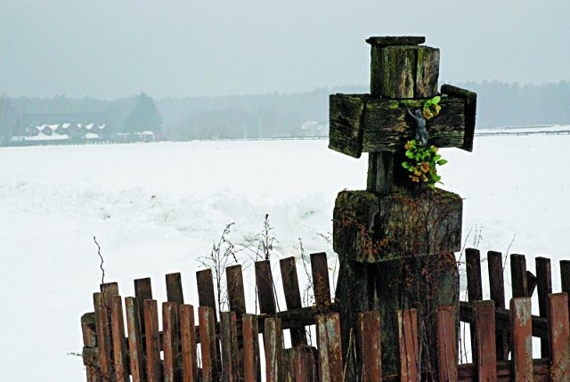 Drewniany krzyż z grobu myśliwego postawiono (po wybudowaniu mu murowanego pomnika) przy drodze. Mieszkańcy Holonek boją się tamtędy chodzić po zmroku...