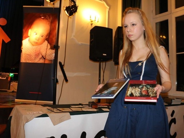 Daria, uczennica Kolegium Kujawskiego, prezentowała przedmioty przeznaczone na licytację.