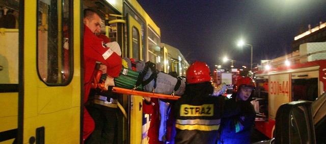 Strażacy i ratownicy wynoszą poszkodowaną w wypadku na ulicy Energetyków.