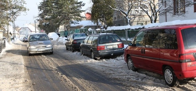 Zastawiona samochodami ulica Sportowa. 