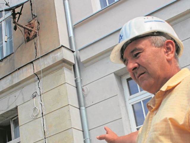 Kierownik budowy Sławomir Strużyna pokazuje powiększającą się  szczelinę w ścianie budynku Liceum im. Marii Konopnickiej