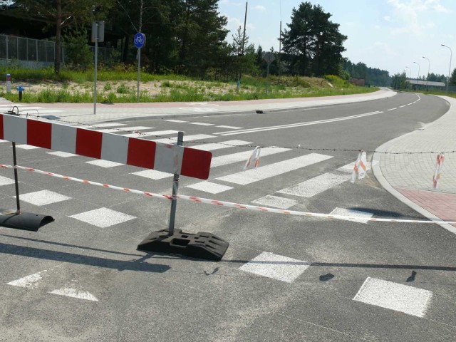 Szlaban i drut kolczasty przy wjeździe na nowo zbudowaną drogę.