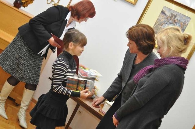 Julia Nowak (w środku) odbiera nagrodę "Super Czytelnika 2010 Roku&#8221; z rąk Stanisławy Mazur (druga z prawej), dyrektor Miejskiej Biblioteki Publicznej w Tarnobrzegu oraz pisarki Beaty Ostrowickiej (pierwsza z prawej).