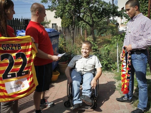 Adam Tołoczko (w czerwonej koszulce) przekazał Marcinowi i jego mamie wózek, koszulkę Jagiellonii, szalik i karnet na mecze