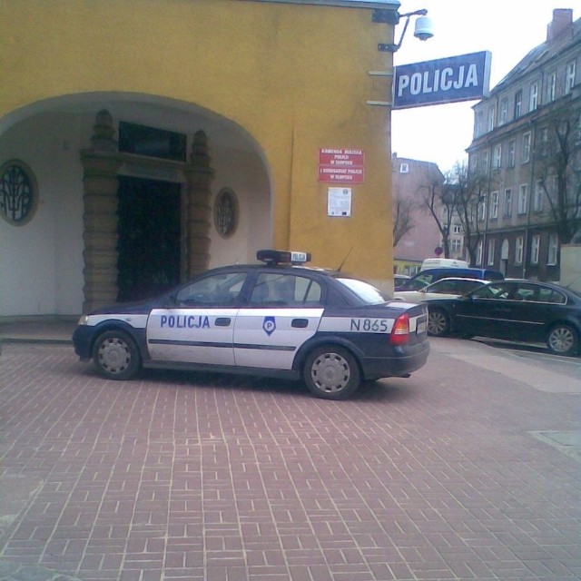 Radiowóz policji parkujący na chodniku przy komendzie na ul. Reymonta.