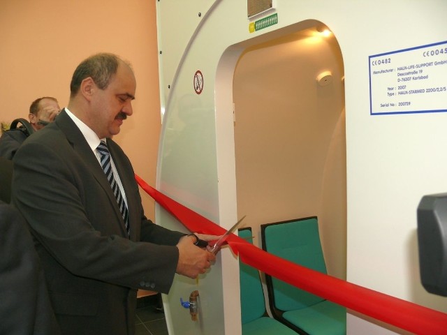 Doktor Zbigniew Gola przecina w lutym 2009 roku wstęgę na otwarcie komory hiperbarycznej.