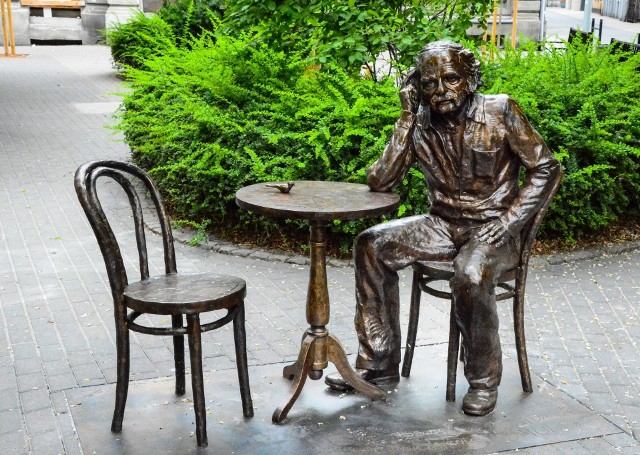 Pomnik wykonany według projektu Piotra Sochy przedstawia postać Smolenia siedzącego na krześle przy stoliku
