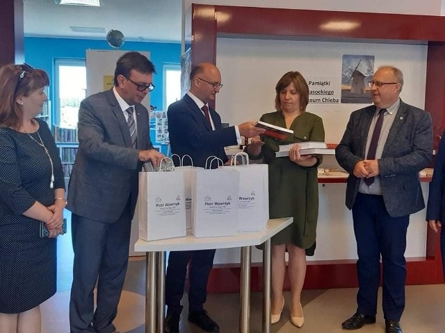 Wiceminister Piotr Wawrzyk przekazuje książki na ręce dyrektor biblioteki w Krasocinie Magdaleny Kowalczyk. Z lewej starosta Dariusz Czechowski i członek Zarządu Powiatu Małgorzata Gusta. Z prawej w&oacute;jt Krasocina Ireneusz Gliściński.