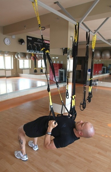 Taśmy TRX umożliwiają zarówno trening cardio, jak i siłowy. W klubie Dynamika można liczyć na pomoc trenera podczas ćwiczeń.