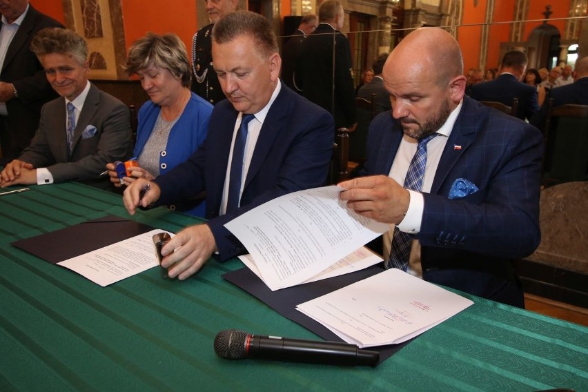 Burmistrz Chęcin Robert Jaworski podpisuje umowę z członkiem...