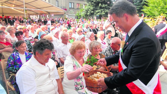 Gospodarze dożynek - na pierwszym planie burmistrz Wacław Gregorczyk - częstują gości chlebem