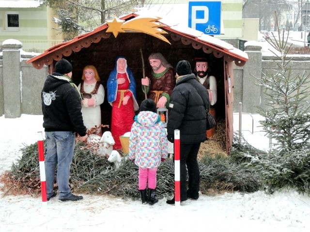 Przechodnie zatrzymują się i podziwiają szopkę