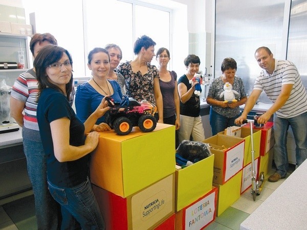 Pracownicy Nutricia chętnie angażują się w akcje na rzecz lokalnej społeczności. Na zdjęciu pokazują nagrody z loterii, z której dochód pomógł sfinansować wycieczkę dla dzieci z domu dziecka. (fot. Nutricia)
