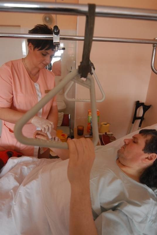 Pielęgniarka Anna Konarska solą fizjologiczną oczyszcza wenflon przed przetaczaniem krwi. Pacjent Janusz Jabłoński z Gorzowa jest po operacji stawu biodrowego.