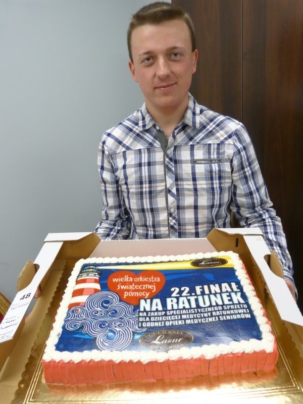 Kamil Garbala z suchedniowskiej Kuźnicy prezentuje tort podarowany przez cukiernię Lazur.