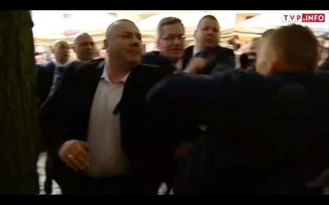 Oficer BOR (z lewej, w białej koszuli) odpycha biegnącego w stronę prezydenta mężczyznę. Zajście sfilmowała kamera TVP