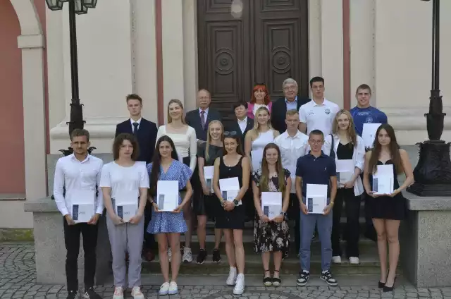 Młodzi stypendyści z przedstawicielami władz miasta na schodach poznańskiego magistratu