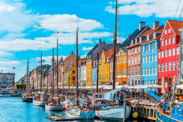 Dania: obostrzenia COVID zaostrzone od 12 listopada 2021. Paszport covidowy będzie niezbędny, co jeszcze się zmieni?Nyhavn to jedno z najbardziej urokliwych miejsc w całej stolicy Danii. Zabytkowe kamienice są pięknie odrestaurowane, a na brzegach kanału cumują wypieszczone łodzie, z których niejedna pełni rolę kawiarenki czy restauracji. Nyhavn słynie jako kawiarniane centrum Kopenhagi i przyciąga turystów z całego kraju i świata.