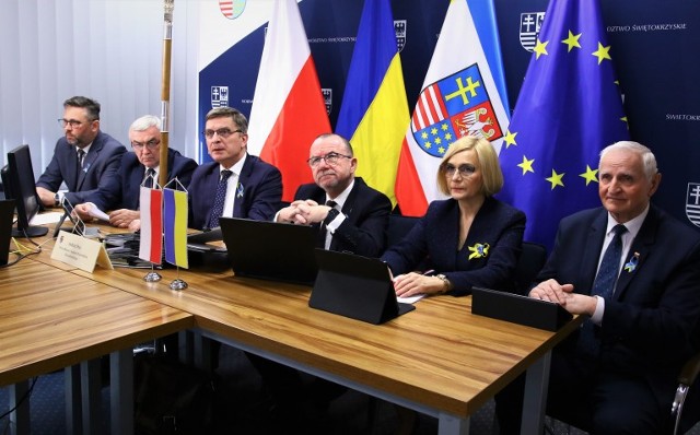 Członkowie Zarządu Wojewodztwa i pzewodniczacy Sejmiku podczas zdalnej sesji Sejmiku - w tle flagi polskie ukraińskie