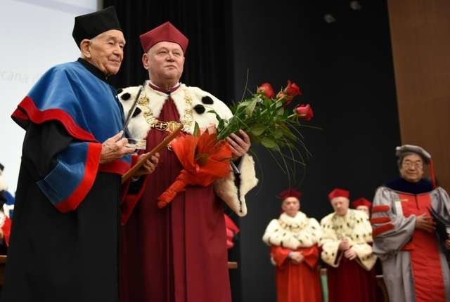 Profesor Andrzej Tomczak przyjmuje z rąk rektora UMK prof. Andrzeja Tretyna wyróżnienie UMK Convallaria Copernicana. Na zdjęciu z prawej prof. James G. Fujimoto