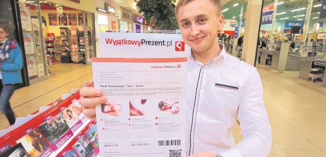 Michał Kubicz, pracownik firmy WyjatkowyPrezent.pl prezentuje voucher do spa. To na pewno będzie ciekawy upominek dla pań.