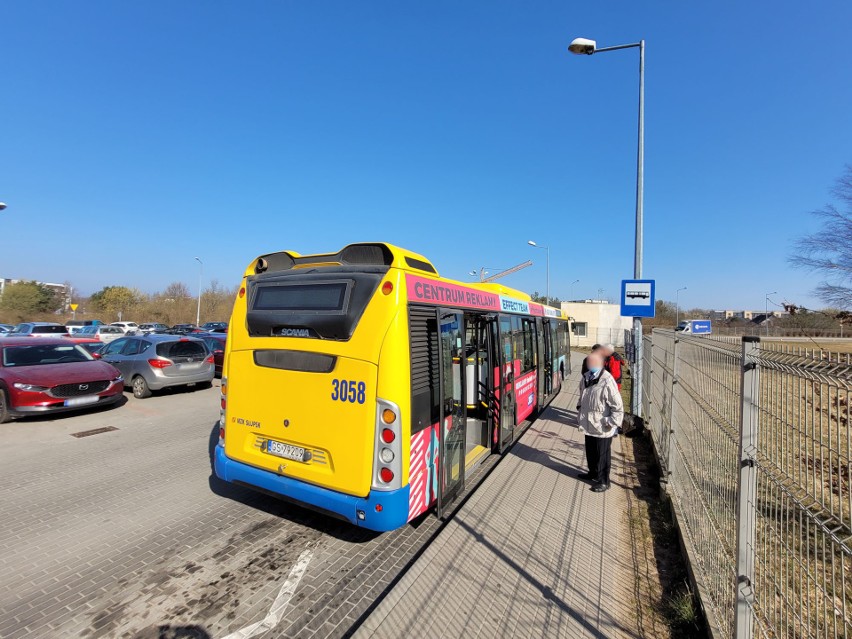 Pasażerowie wsiadający do autobusów z przystanku przy...