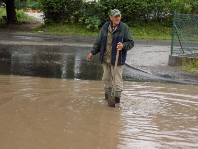 Romuald Mikita z ul. Podgórnej przekopuje rów, żeby deszczówka mogła spłynąć z jezdni.