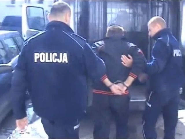 Policjanci prowadzą podejrzanego 49-latka.